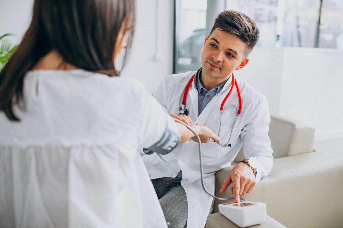 young-male-psysician-with-patient-measuring-blood-pressure_1303-17882